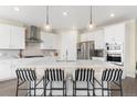 Modern kitchen with stainless steel appliances, pendant lighting, and a large center island at 15640 Spruce St, Thornton, CO 80602