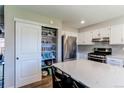 Open kitchen with white cabinets, stainless steel appliances, pantry and a center island at 7244 W Portland Ave, Littleton, CO 80128