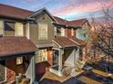Charming townhouse with a covered front porch, brick accents and colorful sky in the background at 7352 E 7Th Ave # 7, Denver, CO 80230