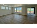 Bright living room with wood floors, large windows, and a sliding glass door to the outdoor deck at 747 Raindance St, Erie, CO 80516