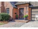 Charming brick home featuring a decorative security door, lush landscaping, and a well-maintained facade at 629 Bellaire St, Denver, CO 80220