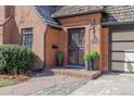 Close up of the front door with black iron security screen and manicured landscaping at 629 Bellaire St, Denver, CO 80220