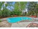Backyard pool with diving board and spa surrounded by a concrete patio and lush landscaping at 629 Bellaire St, Denver, CO 80220