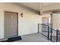 Exterior condo hallway with door to unit 21, showing outdoor light fixture and door lock system at 875 E 78Th Ave # 21, Denver, CO 80229