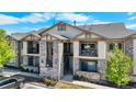 Two-story condo building featuring stacked stone accents, private balconies, and a communal stairwell at 875 E 78Th Ave # 21, Denver, CO 80229