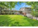 Well-maintained exterior with lush green lawn, beautiful landscaping, and a two-car garage at 3014 E Fremont Dr, Centennial, CO 80122