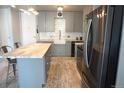 Modern kitchen features gray cabinets, island with marble countertop, stainless steel appliances, and stylish subway tile backsplash at 1050 N Corona St # 206, Denver, CO 80218