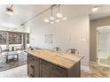 Kitchen with an island featuring a marble countertop next to a living room with floor to ceiling windows at 1050 N Corona St # 206, Denver, CO 80218