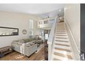 Bright living room featuring hardwood floors, a comfortable sectional sofa, and staircase to a loft at 5017 Ceylon St, Denver, CO 80249