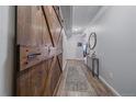 Inviting hallway with wood-look flooring and a stylish sliding barn door feature at 7865 E Mississippi Ave # 1006, Denver, CO 80247