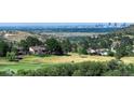 Expansive golf course view with city skyline in distance, showcasing a desirable community at 5979 Willow Springs Dr, Morrison, CO 80465