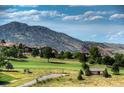 Scenic golf course view with lush green grass and mountain views in the background at 5979 Willow Springs Dr, Morrison, CO 80465