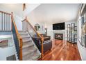 Inviting living space with hardwood floors, a cozy fireplace, and staircase leading to the upper level at 11744 W 71St Pl, Arvada, CO 80004
