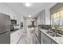 Modern kitchen featuring white cabinets, stainless steel appliances, granite countertops and stylish backsplash at 4051 S Cherokee St, Englewood, CO 80110