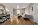 Open-concept living room with hardwood floors, a white sofa, and stylish decor, flowing into other spaces at 4051 S Cherokee St, Englewood, CO 80110