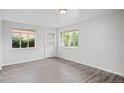 Neutral living room with wood-look floors, freshly painted walls, and a door and windows providing natural light at 4787 Carr St, Wheat Ridge, CO 80033