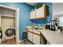 Functional kitchen featuring wooden cabinetry, modern appliances, and a convenient laundry area, maximizing space and efficiency at 19049 E Warren Dr # 105, Aurora, CO 80013