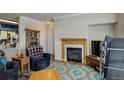 Cozy living room with fireplace, wood mantel, and blue accent rug at 19049 E Warren Dr # 105, Aurora, CO 80013