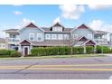 Charming townhome with blue siding, tasteful brick details, mature hedges, and a view from across the street at 9311 Amison Cir # 201, Parker, CO 80134