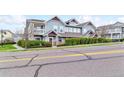 Attractive townhome featuring a blend of blue siding, brick accents, well-kept landscaping, and a street view at 9311 Amison Cir # 201, Parker, CO 80134
