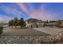 A luxurious home exterior featuring a three-car garage, a spacious driveway, and lush landscaping at 1658 Glade Gulch Rd, Castle Rock, CO 80104