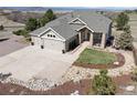 A charming home exterior featuring a three-car garage, a lush lawn, and mature trees at 1658 Glade Gulch Rd, Castle Rock, CO 80104