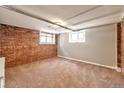 Bedroom with neutral carpet, brick accent wall, and windows for natural light at 2607 E 14Th Ave, Denver, CO 80206