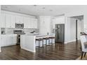 Modern kitchen featuring white cabinets, quartz countertops, and a large island at 8885 S Tibet Ct, Aurora, CO 80016