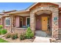 Cozy front porch features stone accents, a seating area, and a welcoming entrance at 8595 Gold Peak Dr # A, Highlands Ranch, CO 80130