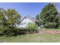 Charming single-story home with blue siding, landscaping and stone retaining wall at 6597 S State Highway 83, Franktown, CO 80116