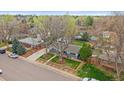 An aerial view of a charming home featuring mature trees, a detached garage, and a lovely yard at 6482 S Cedar St, Littleton, CO 80120