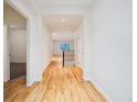 Bright hallway with hardwood floors leading to the staircase and other rooms at 179 N Prairie Falcon Pkwy, Brighton, CO 80601