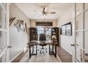 Well-lit home office featuring a desk, ergonomic chair, shelving, and an outside view from the window at 18340 W 85Th Dr, Arvada, CO 80007