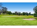 Beautiful green golf course with a sand trap and flag under a clear blue sky at 14001 E Marina Dr # 211, Aurora, CO 80014