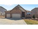 Well-maintained exterior features a stone facade, two-car garage, and a neatly landscaped front yard at 27234 E Quarto Ave, Aurora, CO 80016