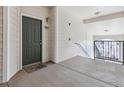 Unit 303 entrance with well-lit hallway, dark front door, and railing leading to the staircase at 18989 E Warren Dr # G303, Aurora, CO 80013