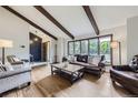 Inviting living room featuring exposed beams, large windows, and hardwood floors at 10397 Yates Ct, Westminster, CO 80031