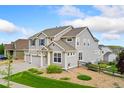 Angle view of a light grey home with a three-car garage and manicured front yard at 19316 W 84Th Pl, Arvada, CO 80007