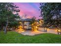 Beautiful home exterior with stone and stucco, three-car garage, manicured lawn, and mature landscaping at 22554 Treetop Ln, Golden, CO 80401