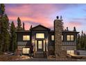 Beautiful home exterior with a stone chimney and picturesque sunset backdrop at 400 Upper Forest Rd, Idaho Springs, CO 80452