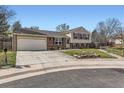 Inviting two-story home with a spacious driveway, attached garage, and manicured landscaping at 7153 S Cody Cir, Littleton, CO 80128