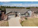Stunning aerial view of a home showcasing its expansive driveway, two-car garage, and beautifully landscaped surroundings at 15137 W 50Th Pl, Golden, CO 80403