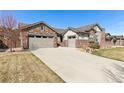 Beautiful single Gathering home with a manicured lawn and long driveway leading to a two car garage at 15137 W 50Th Pl, Golden, CO 80403