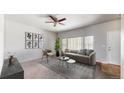 Bright living room offering neutral decor, a ceiling fan, and floods of natural light from a large window at 169 Westin Ave, Brighton, CO 80603