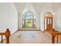Spacious living room with a large arched window and adjacent front door at 15916 E Crestridge Pl, Centennial, CO 80015