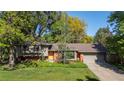 Charming single-story home features a brick facade, lush lawn, mature trees, and a two car garage at 255 Kiowa Pl, Boulder, CO 80303