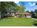 Charming single-story home features a brick facade, lush lawn, mature trees, and a two car garage at 255 Kiowa Pl, Boulder, CO 80303