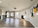 Bright, open-concept living area features wood-look floors, a cozy fireplace, and large windows at 21993 E Jamison Pl, Aurora, CO 80016