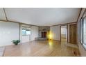 Cozy living room with a stone fireplace, hardwood floors, and large window at 8509 Colorado Ct, Denver, CO 80229
