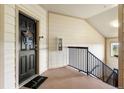 Apartment entryway with a black door, welcome mat, and access to stairs at 5745 N Genoa Way # 306, Aurora, CO 80019